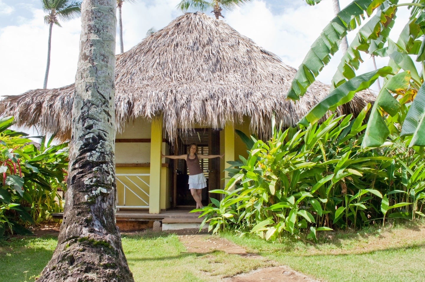 woman standing in thatch bungalow