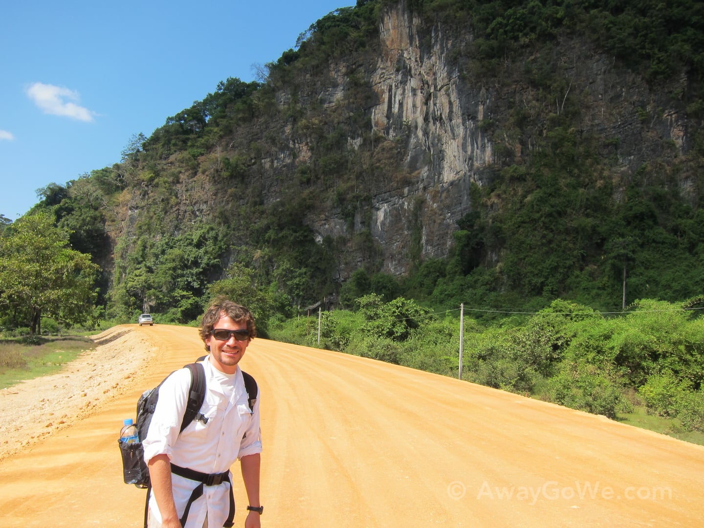 standing along the dirt road to buddha cave on the thakhek loop in laos