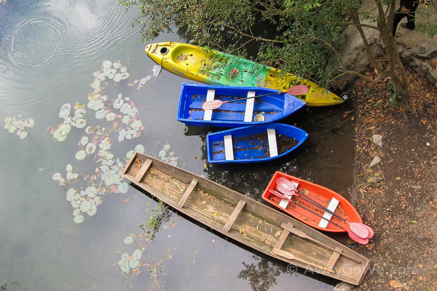 wooden and plastic boats near buddha cave