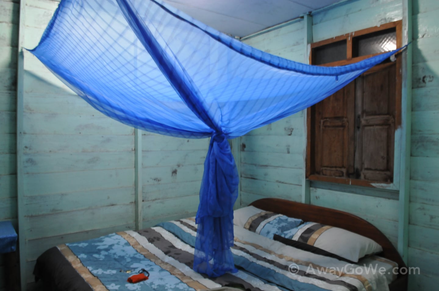 bed and net inside wooden bungalow in laos