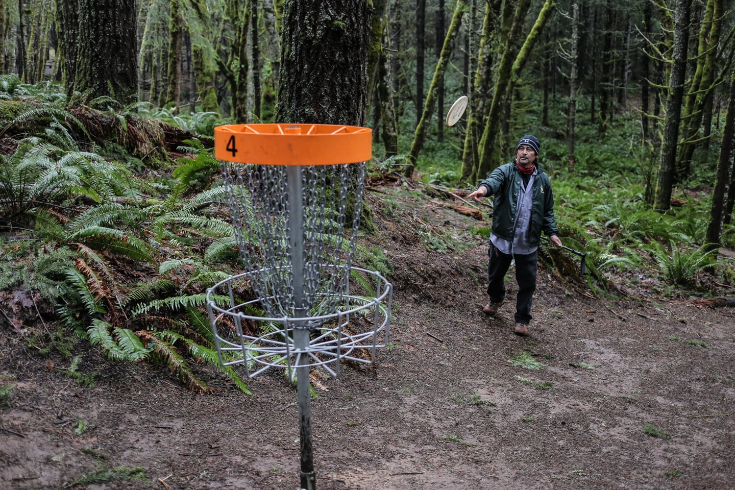 man playing disc golf in the Pacific Northwest woods