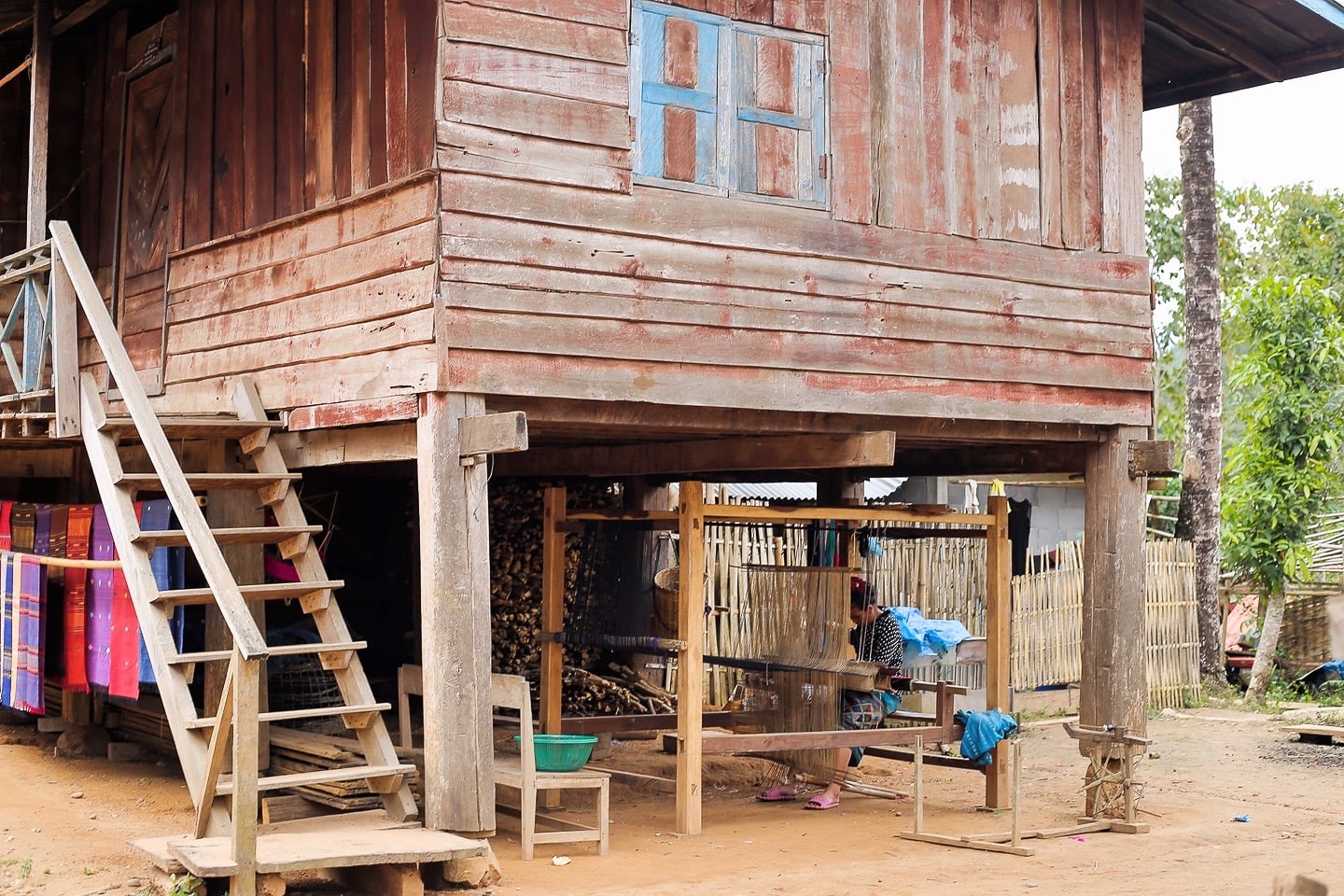 Lao weaver under house in Sop Cham village Laos