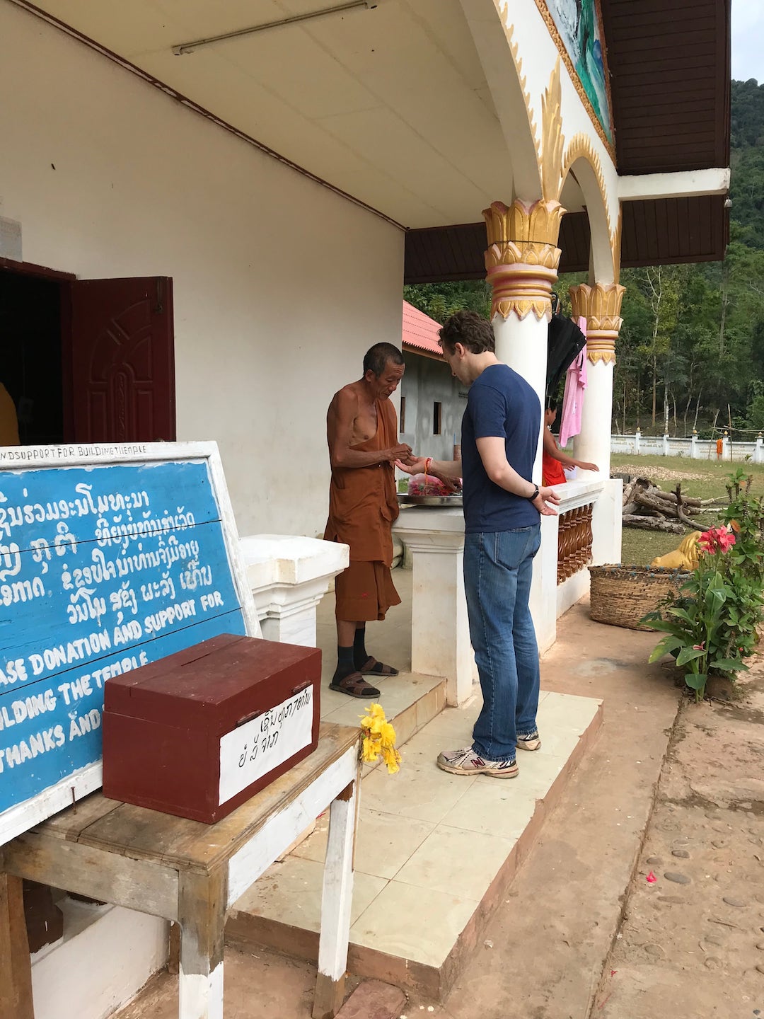 receiving a blessing from a Buddhist monk in Muang Ngoi Neua